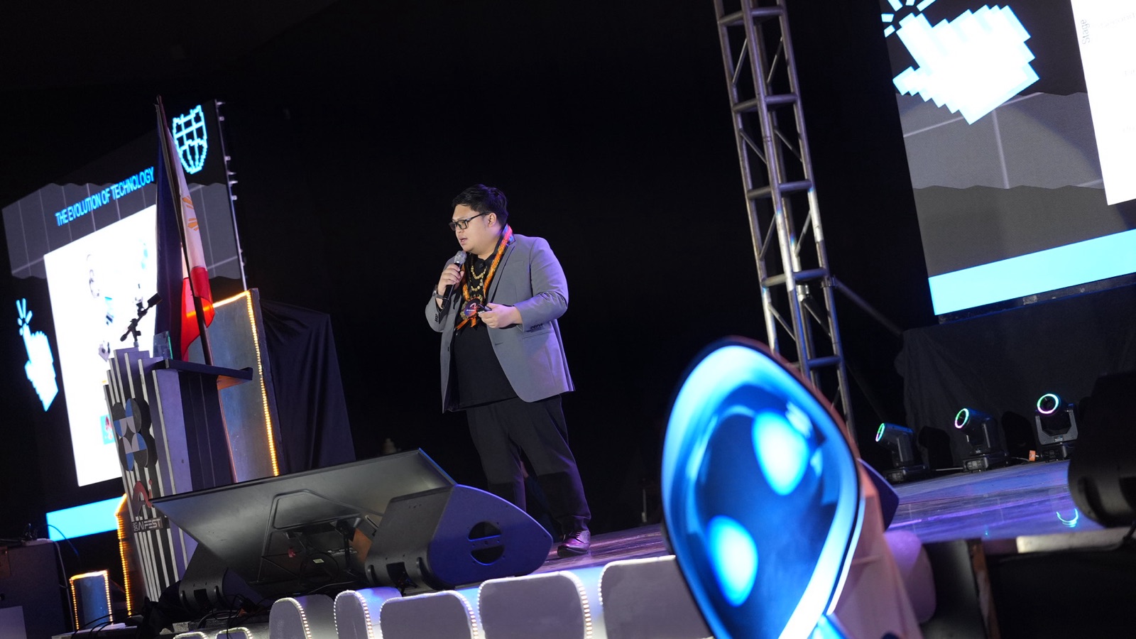 Cris Vinson speaking on stage under a spotlight